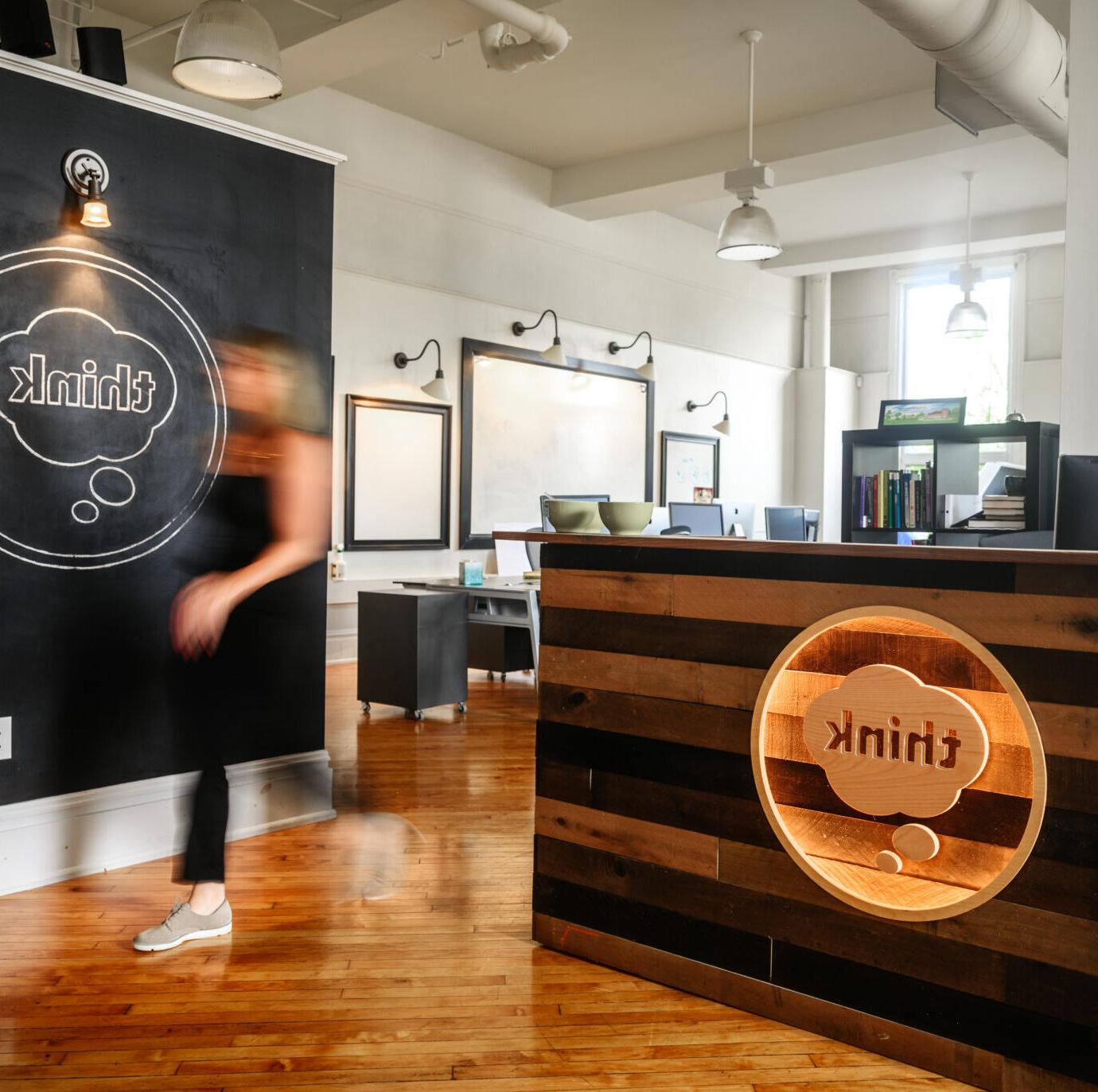 front desk with think logo and blurry person walking by
